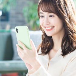 スマホで無料査定依頼を行う女性