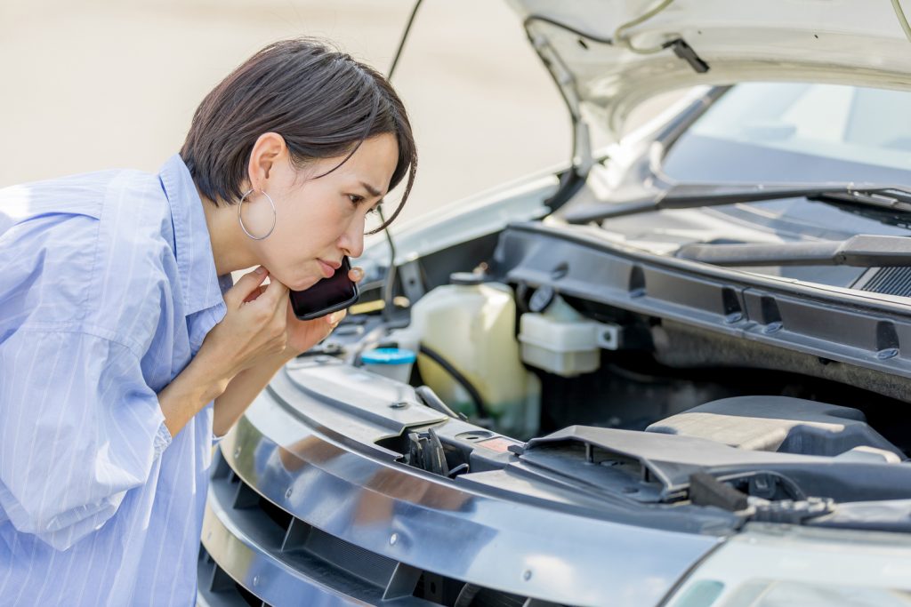 車を心配そうに見つめる女性